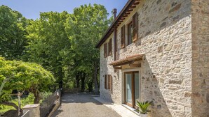 Un bâtiment en pierre avec un chemin de gravier menant à une porte en bois.