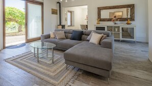 Un salon moderne avec un canapé d’angle gris, une table basse en verre et un plancher en bois.