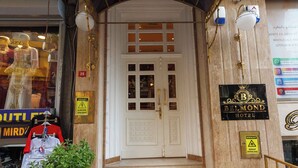 L'entrada de l'Hotel Bellevue, amb un disseny clàssic, un conjunt d'escales que condueixen a la porta i una placa amb el nom de l'hotel.