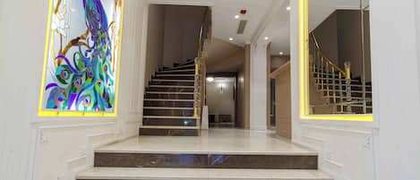 A grand staircase with marble steps leading to a second floor.