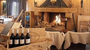 Un intérieur chaleureux avec une cheminée, des meubles en bois et un présentoir à vin.