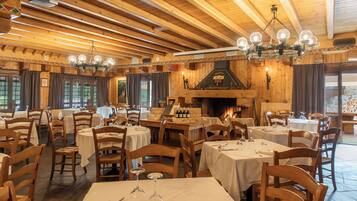 Ein Restaurant mit Holzeinrichtung, mehreren Tischen und einem Kamin.