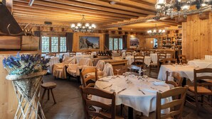 Un restaurant au décor intérieur en bois, avec des tables rondes et des lustres.