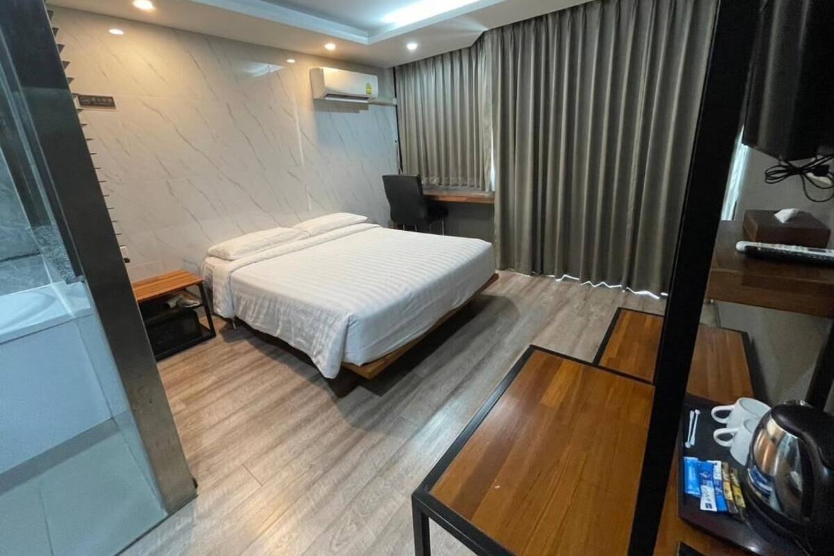 Ein modernes Hotelzimmer mit einem großen Bett, einem Schreibtisch und einem Fernseher.