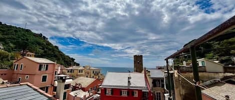 Un pueblo costero con edificios, un edificio rojo destacado y una torre.