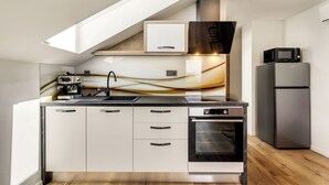 A modern kitchen with a built-in oven, a microwave, and a coffee maker. - Lux Apartment close to castle Podreda with balcony 2 unit (Šmarje pri Jelšah)