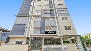 Un edificio de varios pisos con un diseño moderno, que presenta un llamativo letrero 'Collection' en la fachada.