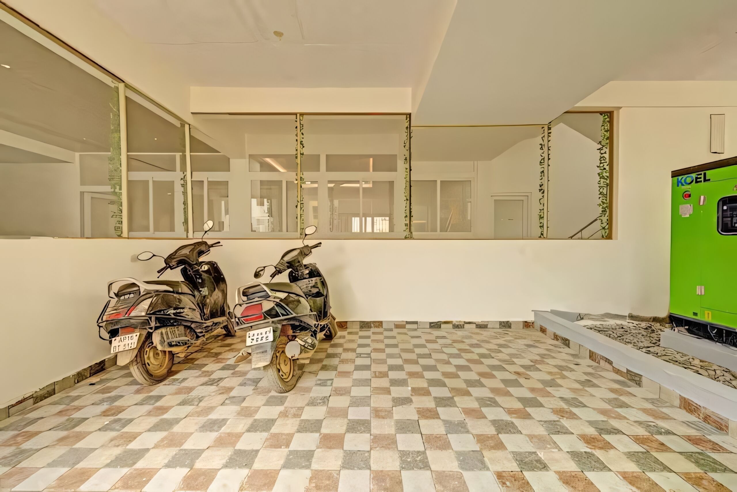 Een kamer met een zwart-wit schakeerdvloer, twee scooters tegen de muur geleund, een groen apparaat, en een grote spiegel die de kamer reflecteert.