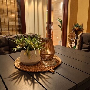 Una mesa de comedor con un mantel tejido, una planta en maceta y un candelabro de vidrio.