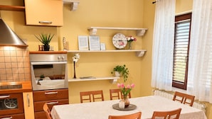 A dining area with a table set for six, surrounded by wooden chairs.