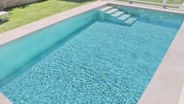 A rectangular swimming pool with clear water and steps leading into it. - El Rincon de Lidia . (Conil de la Frontera)