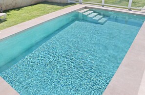 A rectangular swimming pool with clear water and steps leading into it. - El Rincon de Lidia . (Conil de la Frontera)
