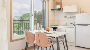 Une cuisine moderne avec un coin repas, de grandes fenêtres et une vue sur la verdure.