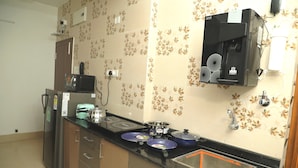 Une cuisine équipée d’un réfrigérateur, d’un four à micro-ondes, d’une cuisinière et d’une machine à café.