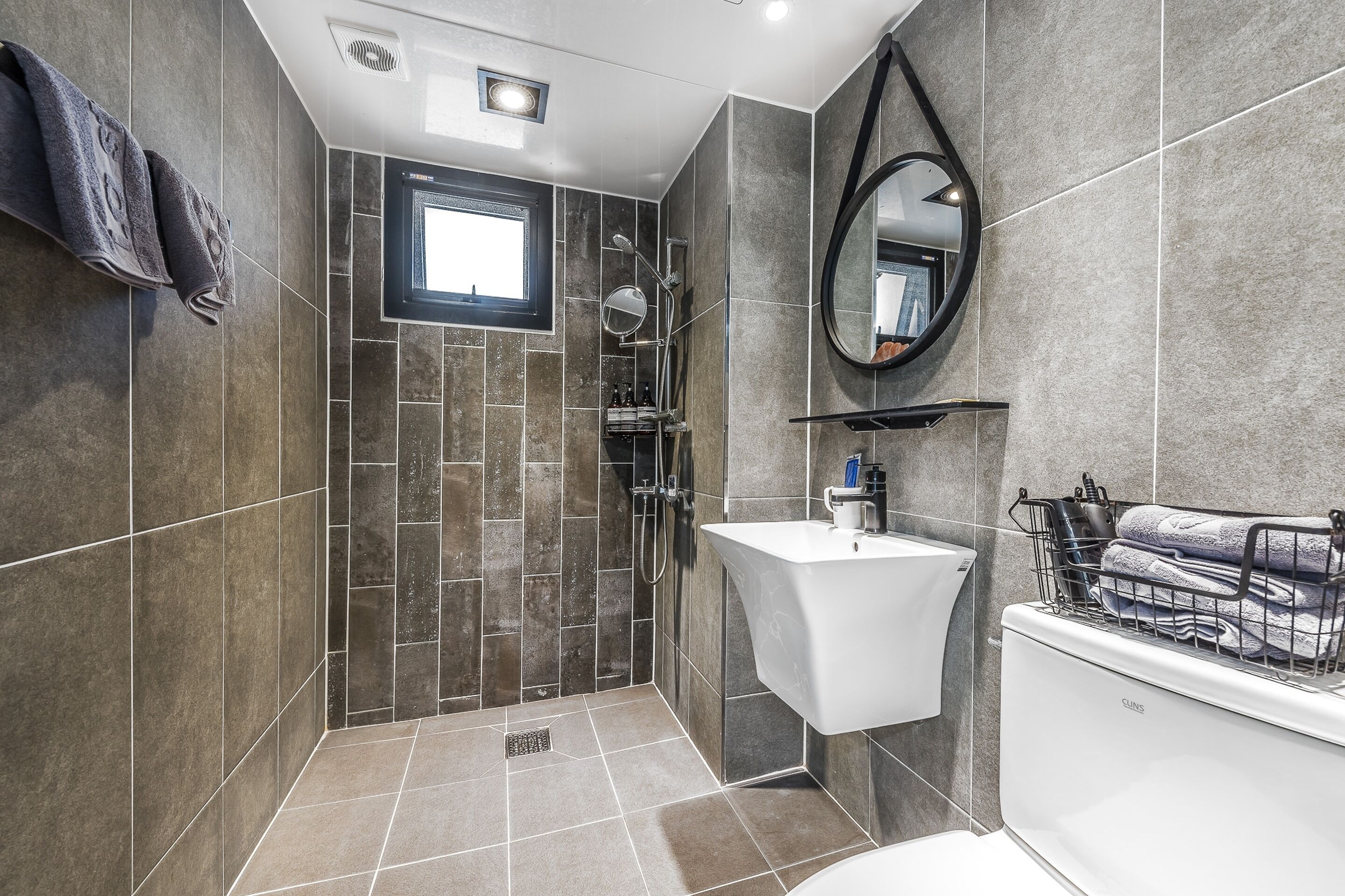 Un baño moderno con ducha, lavabo y espejo.