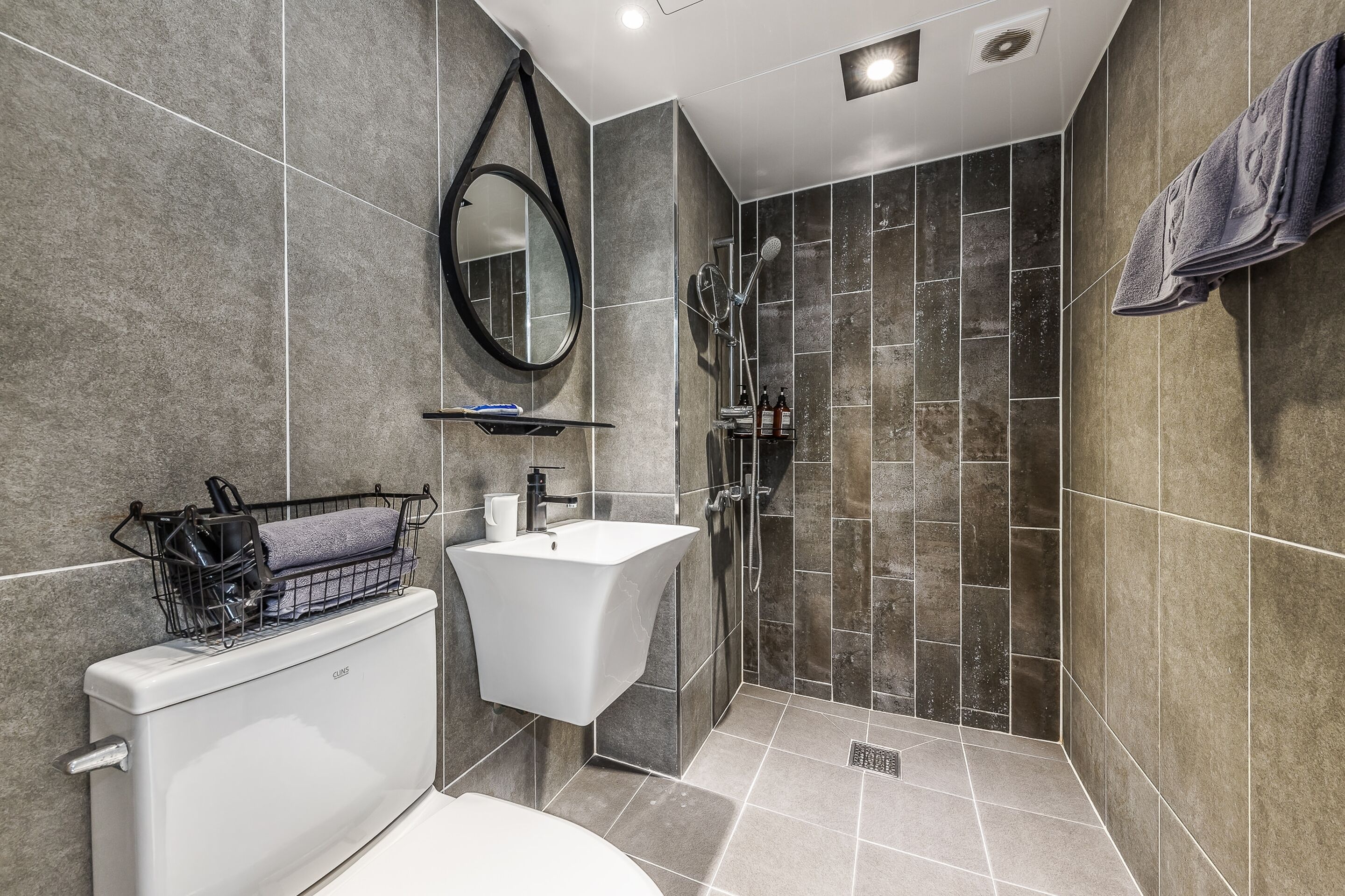 Ein modernes Badezimmer mit Toilette, Waschbecken und Dusche.