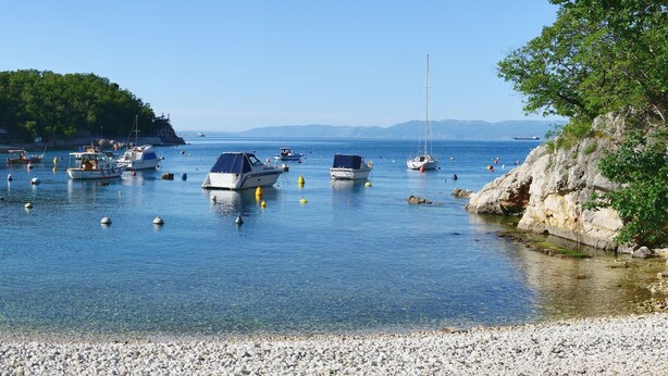 A calm harbor with boats anchored in clear water, surrounded by rocky shores and greenery. - Seaview Apartment Kostrena Two (Kostrena)