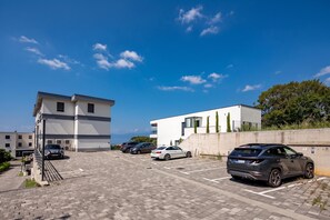 A parking area with modern buildings and parked cars. - Seaview Apartment Kostrena Two (Kostrena)