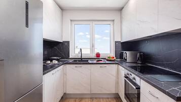 A modern kitchen with a built-in oven, a microwave, and a sink.