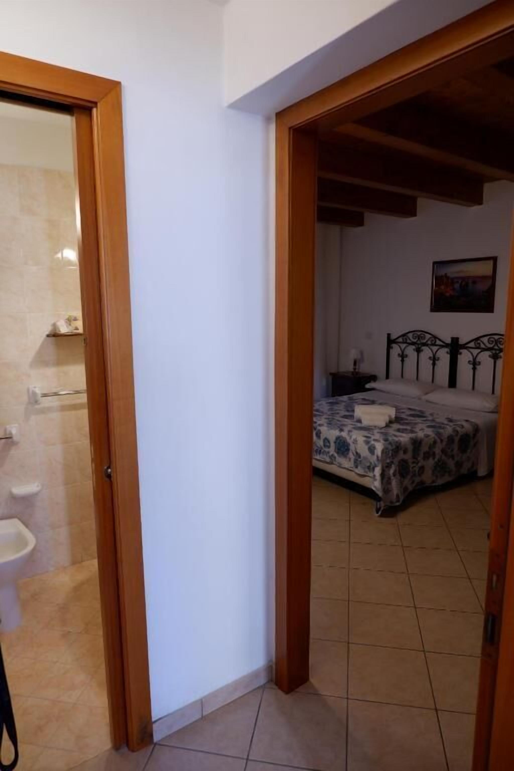 A bedroom with a bed, a nightstand, and a painting on the wall.