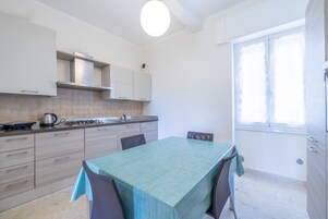 Una cocina moderna con una mesa de comedor, armarios y una ventana.
