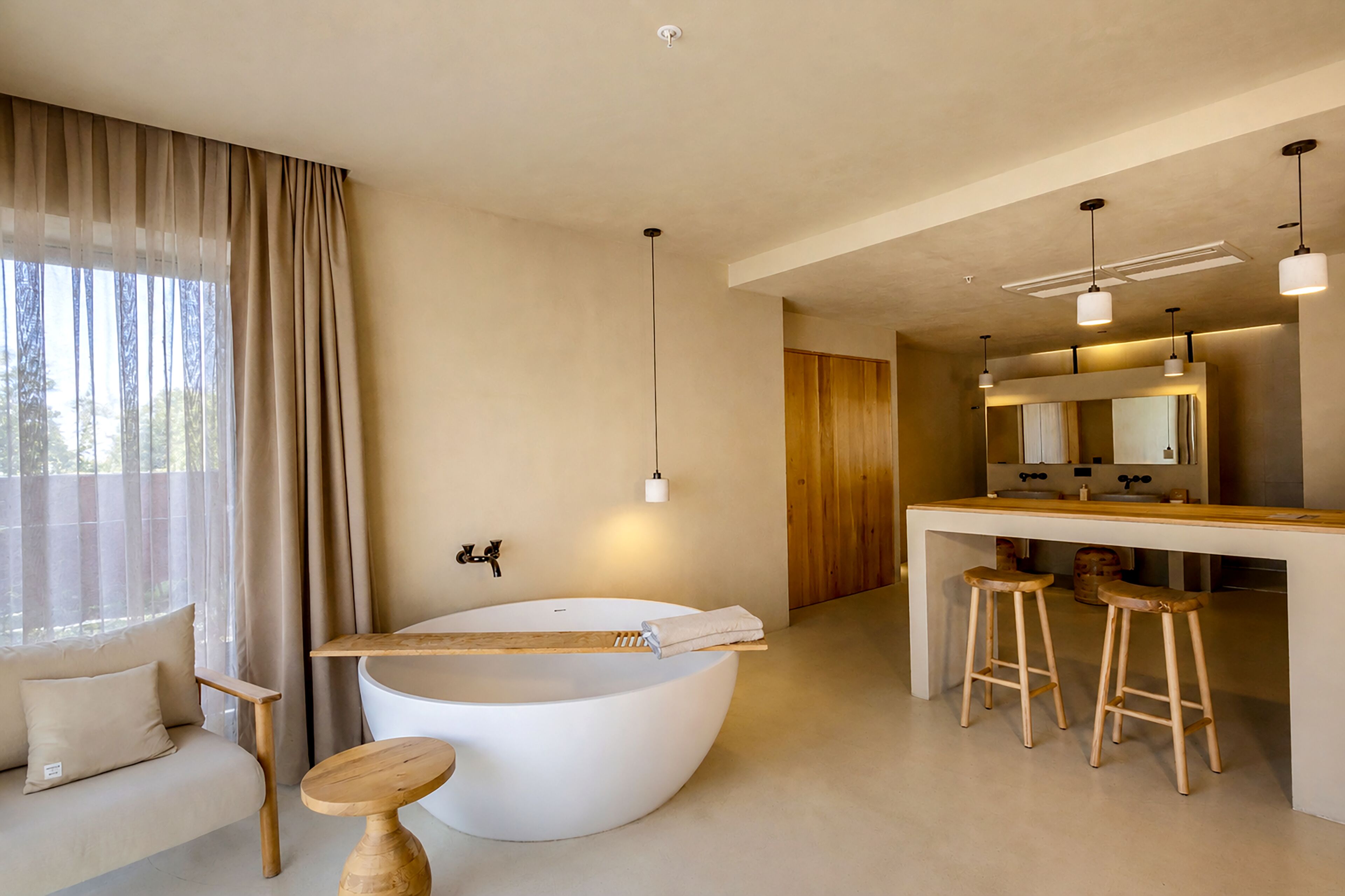A modern bathroom with a freestanding bathtub, a wooden vanity, and a large mirror.