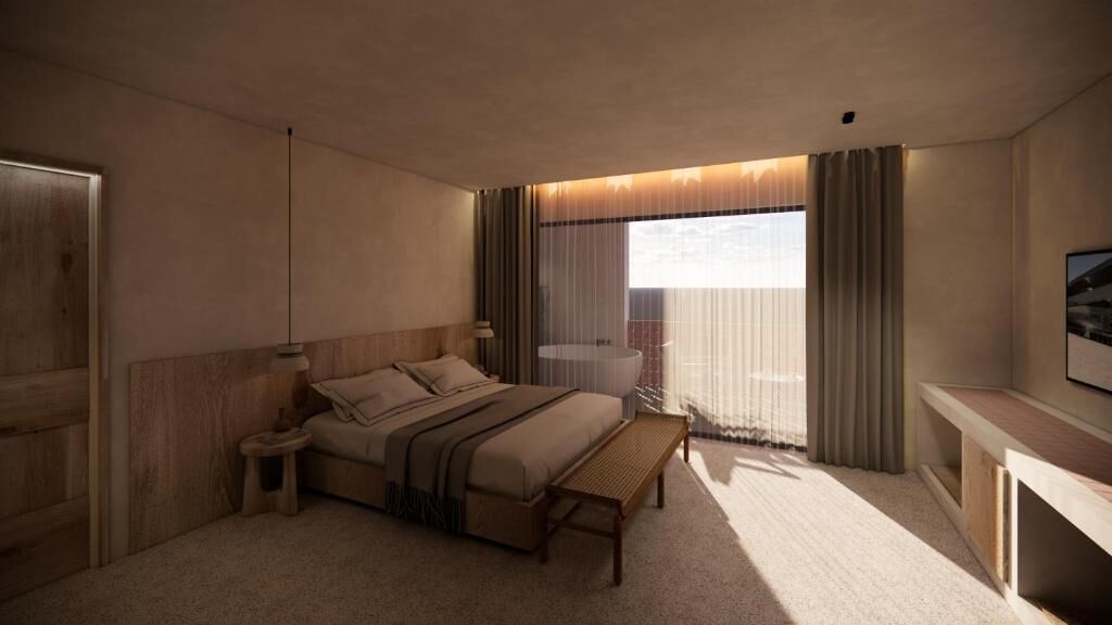 Habitación de hotel moderna con una cama grande, mesita de noche y vista a la ciudad a través de cortinas translúcidas.