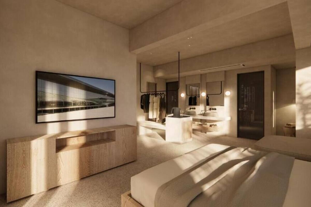 Een moderne slaapkamer met een groot bed, een houten console, een badkamer met spiegel en wastafel, en een ingelijst schilderij aan de muur.