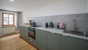 A modern kitchen with a built-in oven, a stovetop, and a sink. - CoView Pirna - Altstadt - Parkplatz (Pirna)