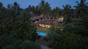 A resort with multiple buildings, a swimming pool, and surrounding palm trees. - Villa Thamburu (Bentota)