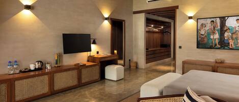 A modern hotel room with a flat-screen TV, a wooden console table with amenities, a large bed, and a painting on the wall.