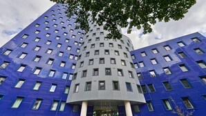 A modern building with a unique cylindrical central section and blue facades.