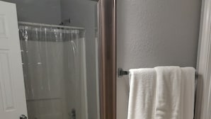 Un baño con un lavamanos blanco, un espejo y un perchero para toallas.
