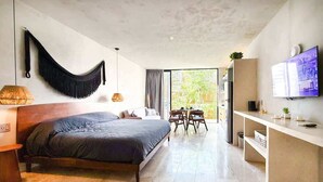 A modern bedroom with a large bed, a desk, and a TV. - Private Pool & Grill 2 Bedroom Apartment 417Selva (Tulum)