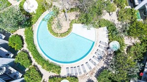 An aerial view of a resort with a large circular pool surrounded by lounge chairs and greenery. - Private Pool & Grill 2 Bedroom Apartment 417Selva (Tulum)