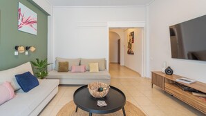 A modern living room with a sofa, a coffee table, a TV, and a hallway leading to another room. - Residence City Frida (Rodos)
