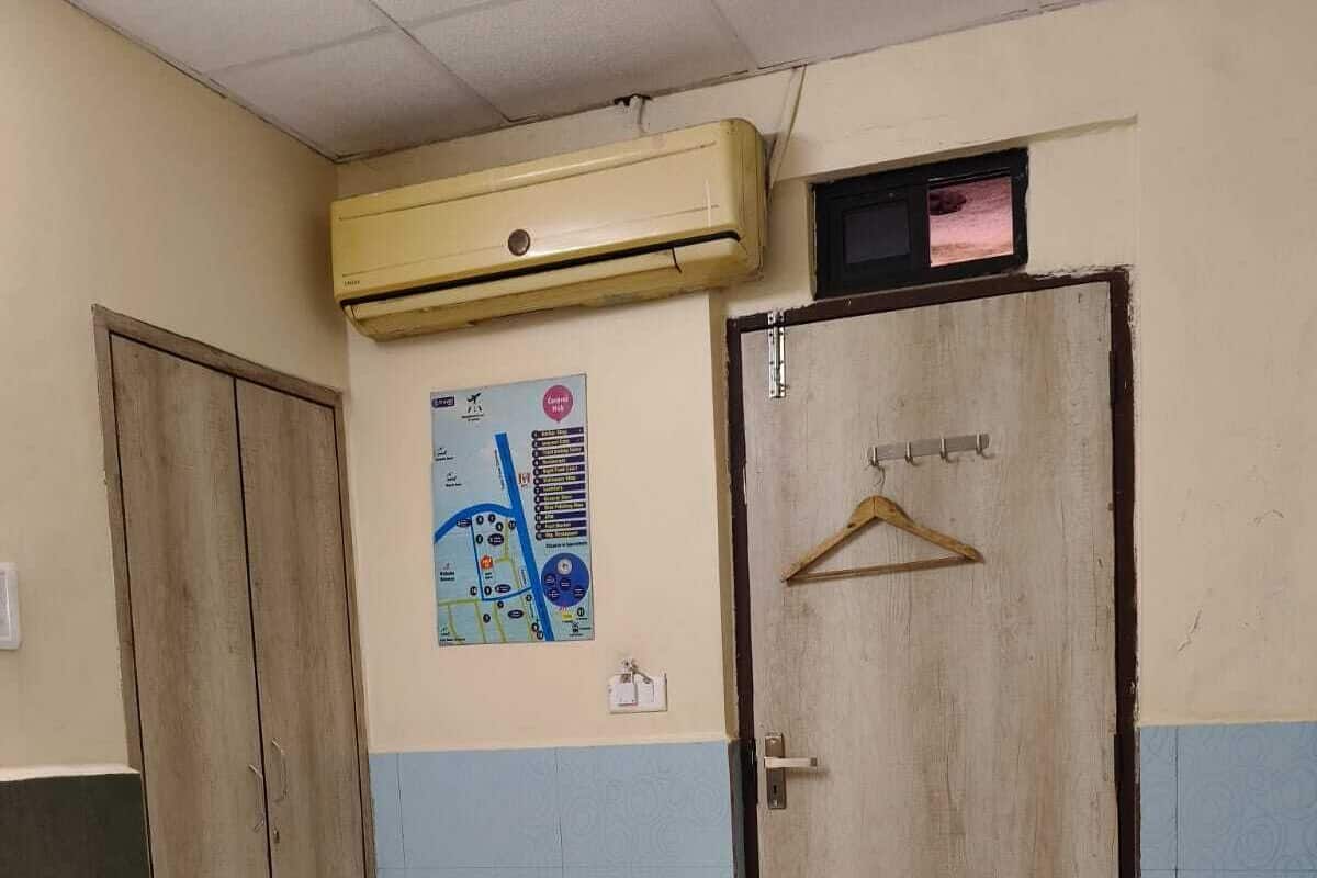 Una stanza con una porta in legno, un condizionatore d'aria a muro e una mappa appesa al muro.