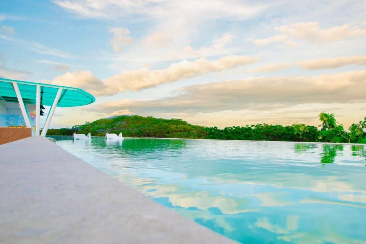 A pool area with a clear view of the water and a distant shoreline.