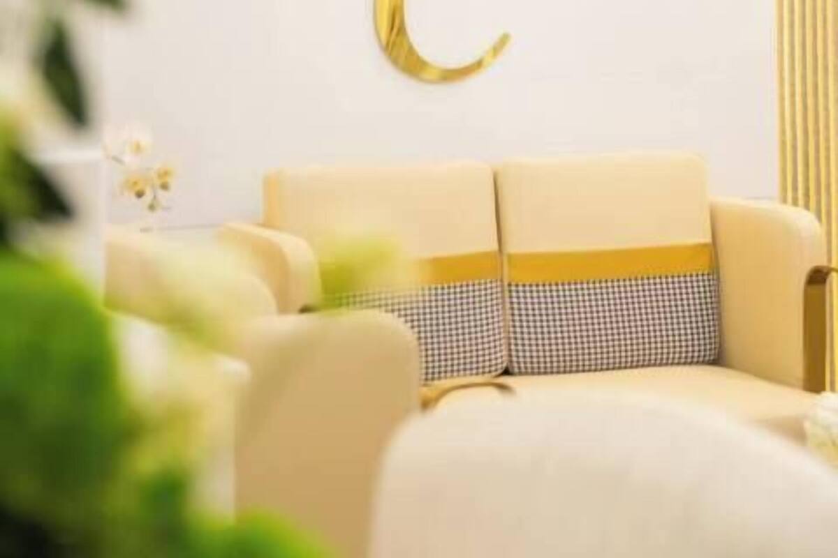 Une pièce avec un mur blanc, une décoration en forme de couronne dorée et les lettres « RC » en dessous.