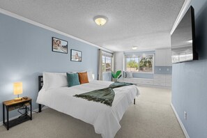A bedroom with a bed, bedside table, lamp, and a window with a view. - Desert Dreams Retreat Hot Tub Game Room Fire Pit (Sparks)