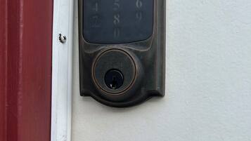 A door lock with a numeric keypad and a keyhole.