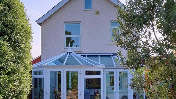 A conservatory attached to a house with a glass roof and white walls. - Charming Villa in Ryde - Child Friendly (Ryde)