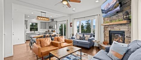 A spacious living room with leather sofas, a coffee table, and a fireplace.
