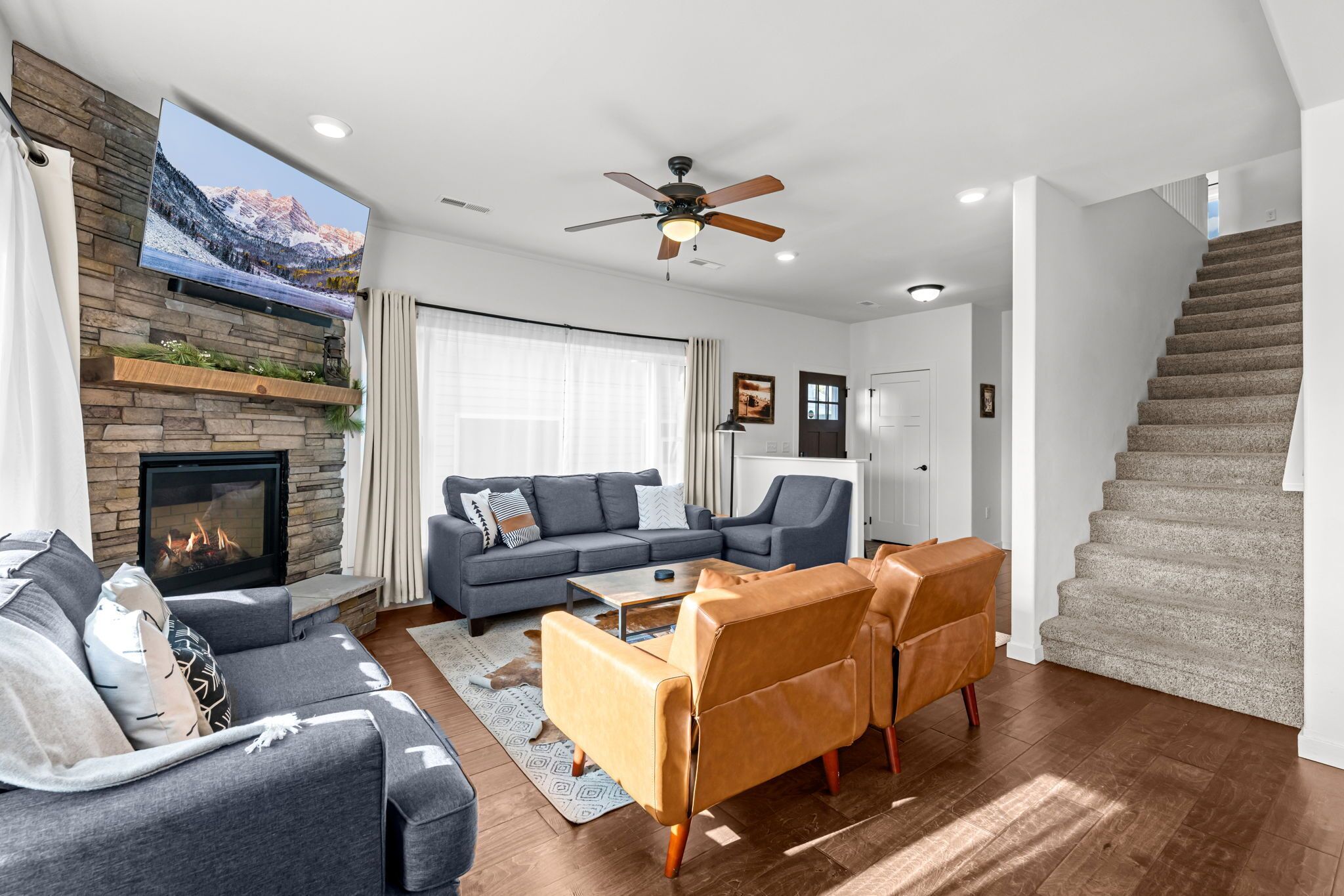 Una sala de estar moderna con chimenea, un sofá, una mesa de centro y una escalera.