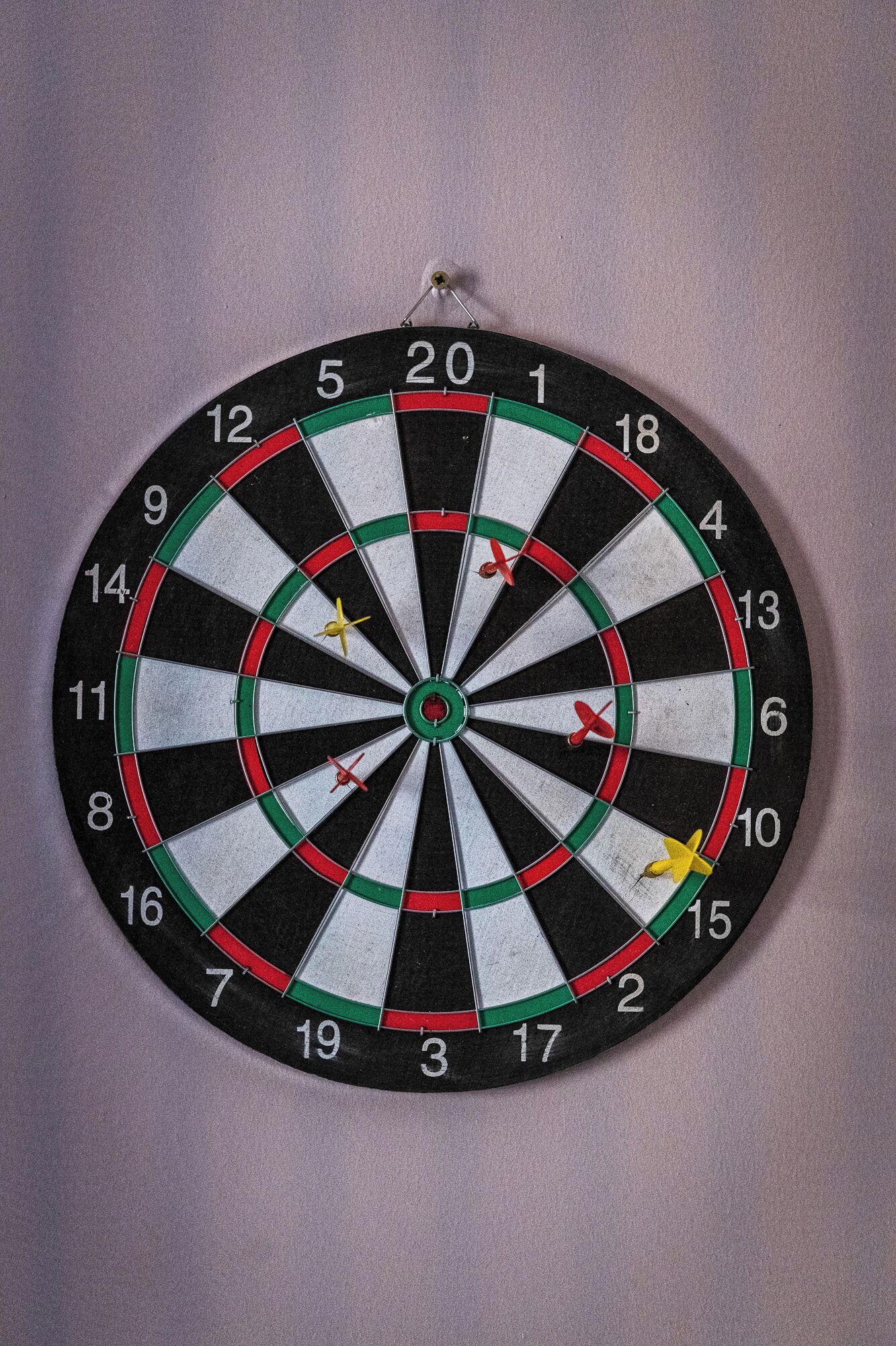 A dartboard with multiple darts stuck in it.