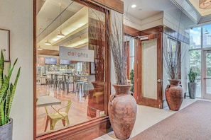 A restaurant with a modern interior, large vases, and a sign reading 'delights.'