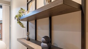 A shelf with a potted plant, a glass hourglass, and a decorative vase. - Student Only Port on the Square (Bristol)