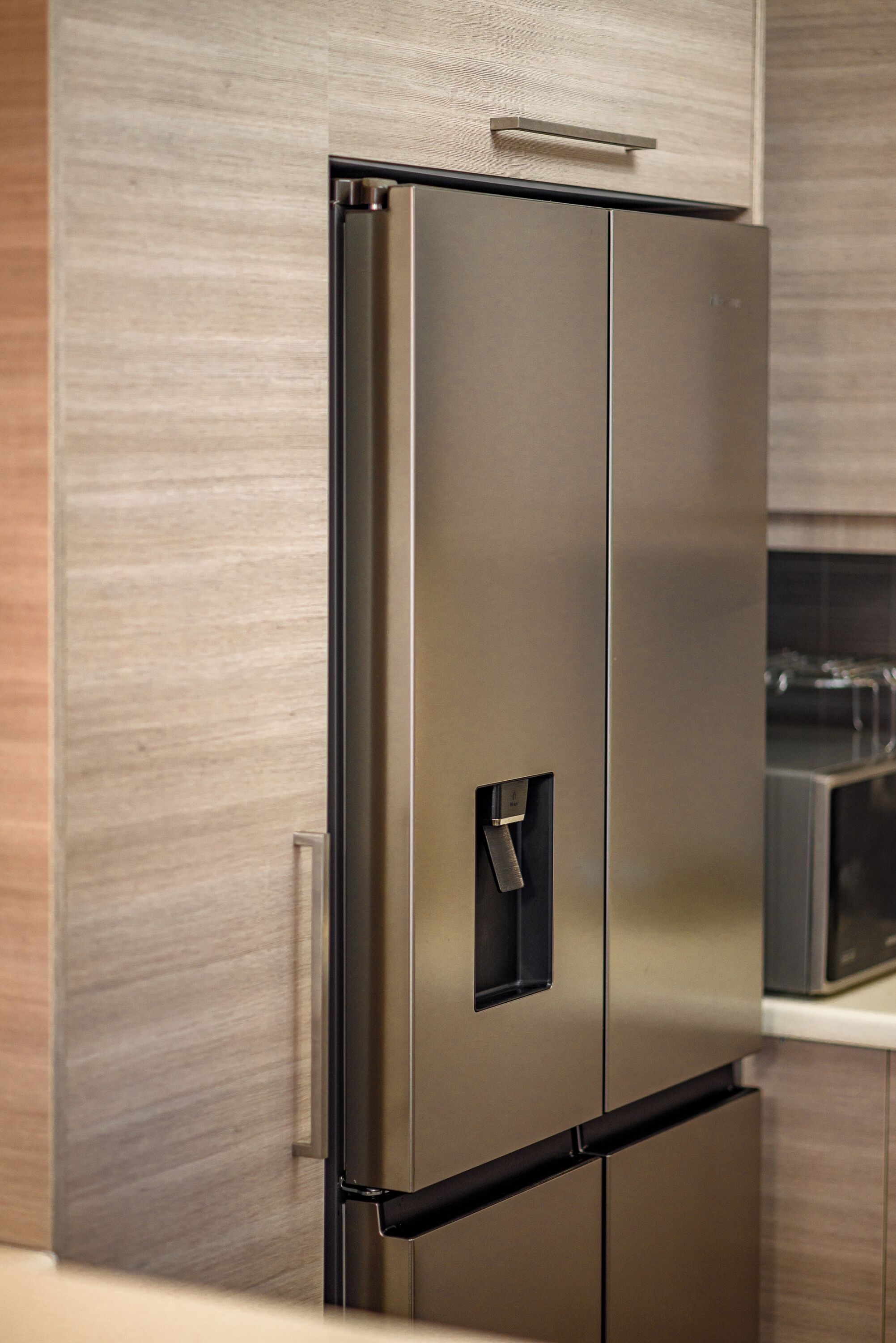 Ein Edelstahl-Kühlschrank mit Griff und einem Gefrierfach.