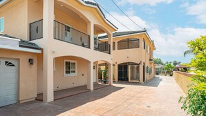 A multi-story house with a covered patio, a garage, and a large window. - Modern Getaway Near Pasadena Dtla (Rosemead)