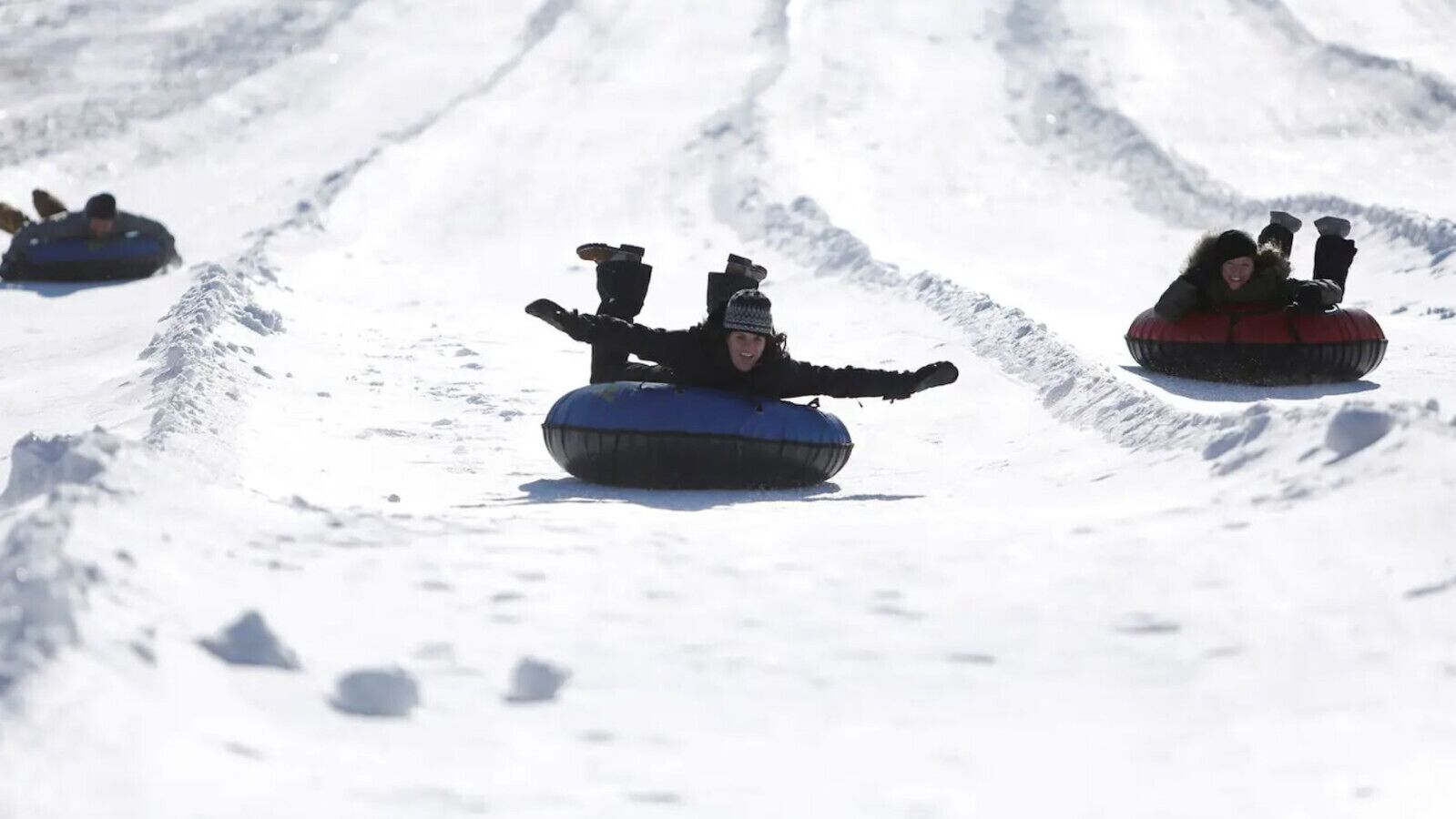 People sledding down a snowy slope.